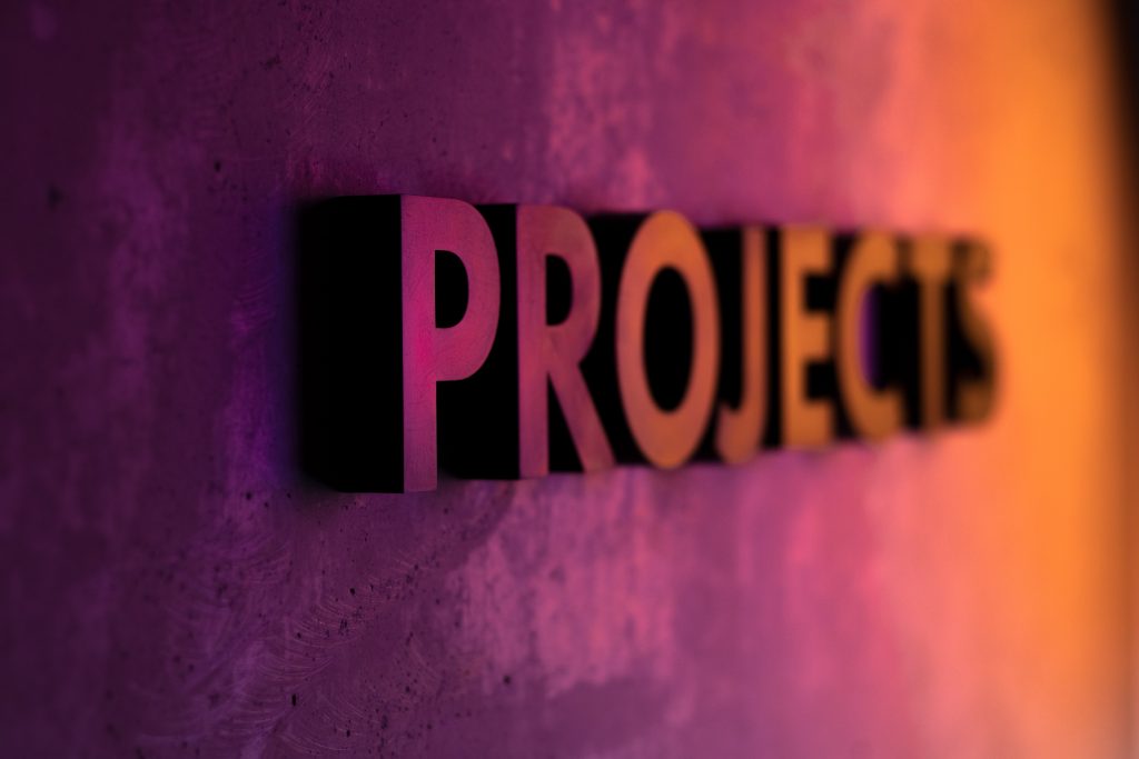 The word ‘project’ is written in purple, pink, and orange on a background of the same colors.
